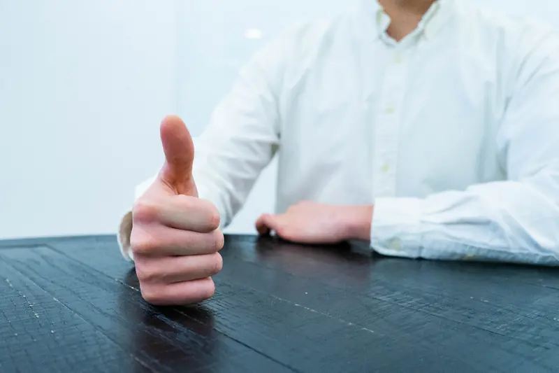 Persona haciendo el gesto de pulgar arriba