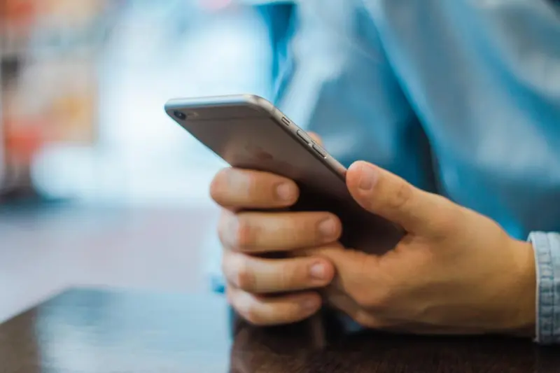 Manos escribiendo un mensaje en el celular
